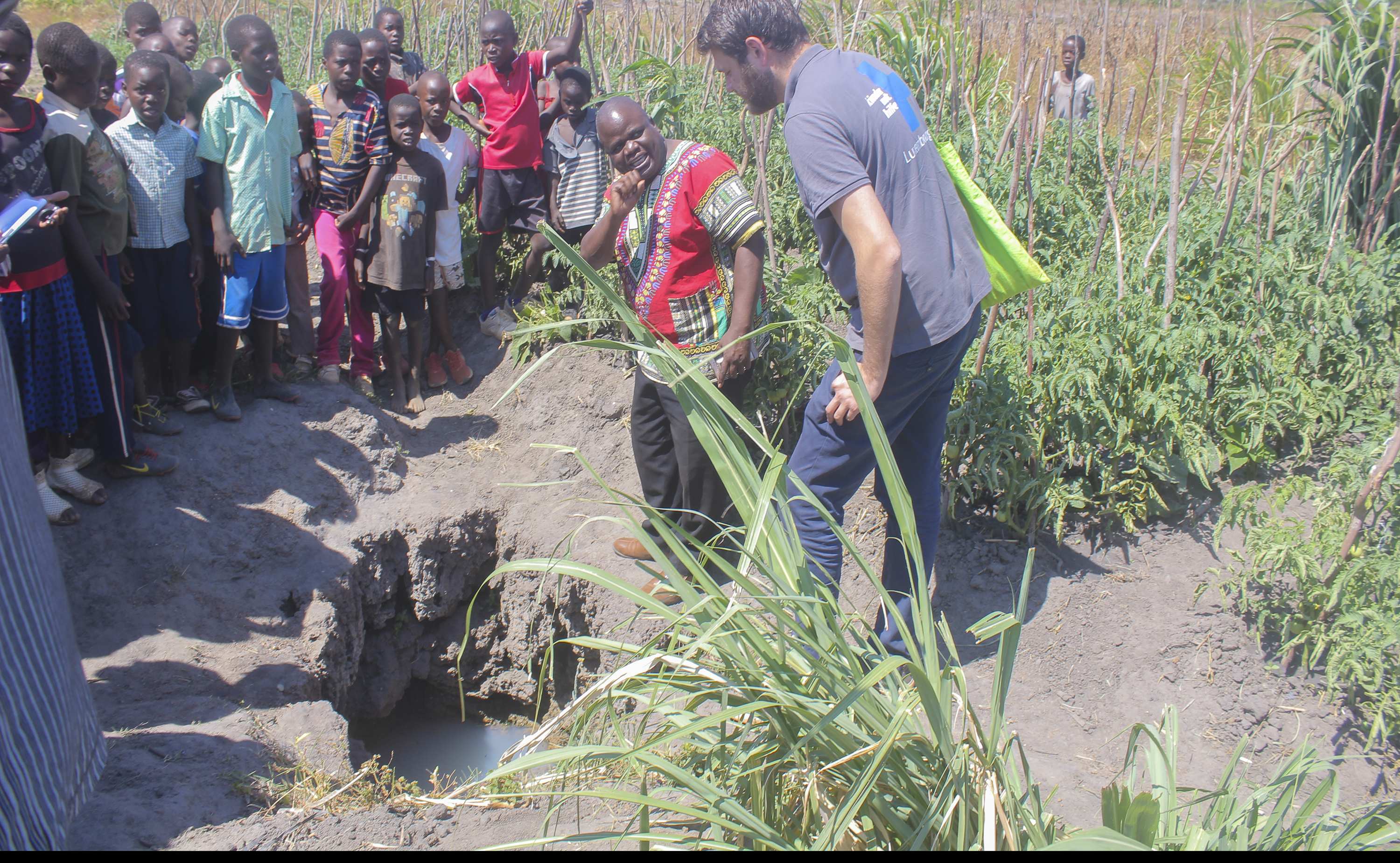 Einheimischer zeigt Brunnen 