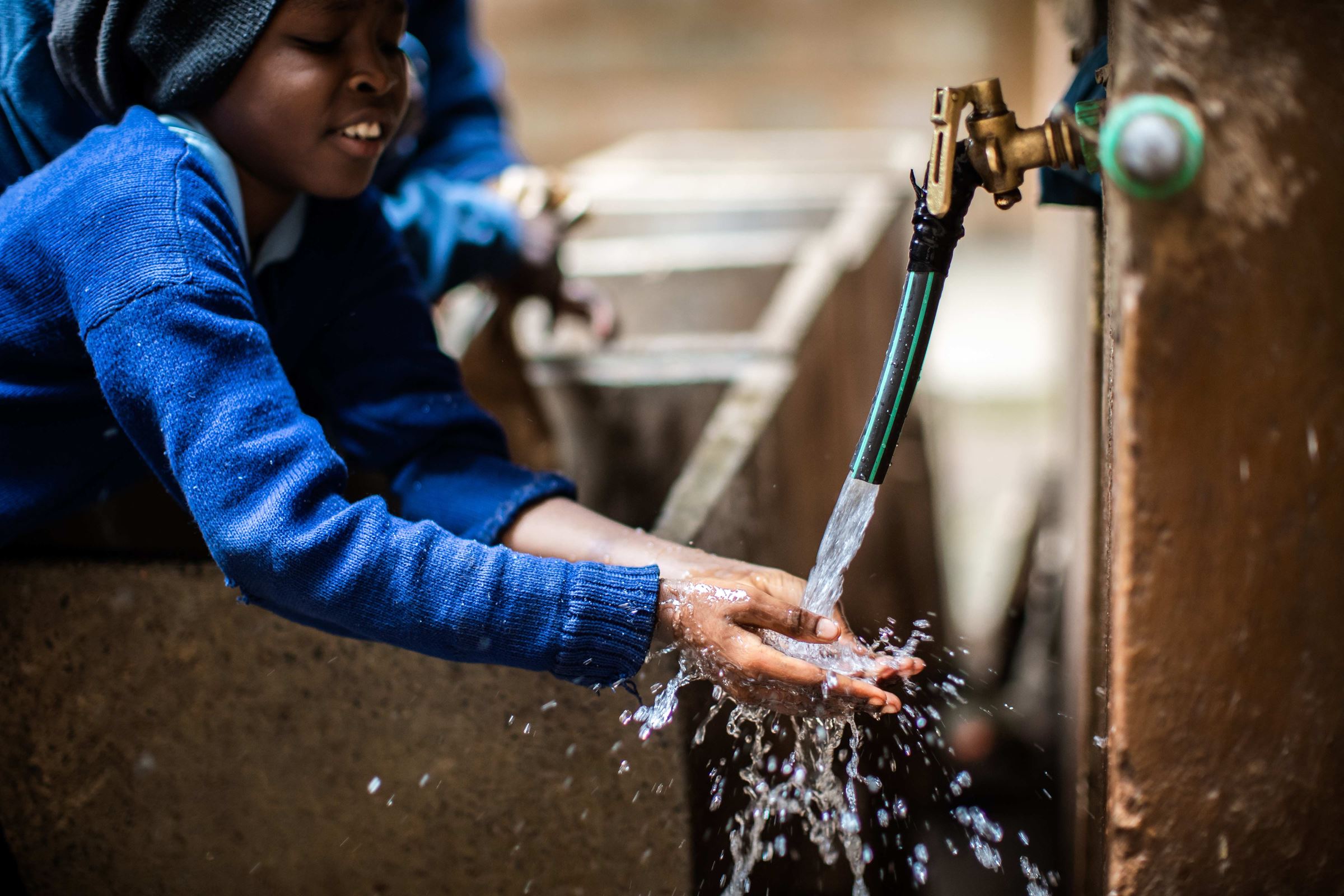 Kind wäscht Hände an Brunnen  Kind wäscht Hände an Brunnen